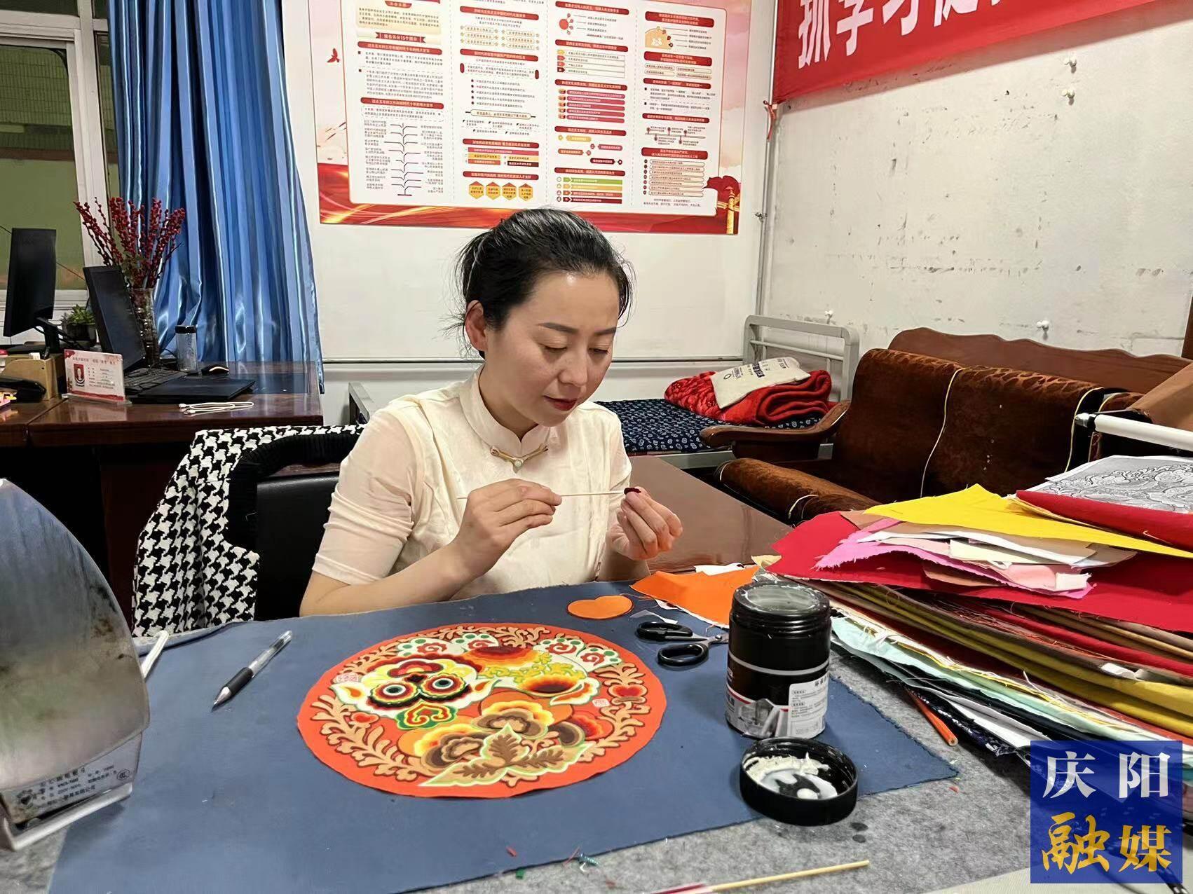 李慶英正在創(chuàng)作布貼畫(huà)作品。